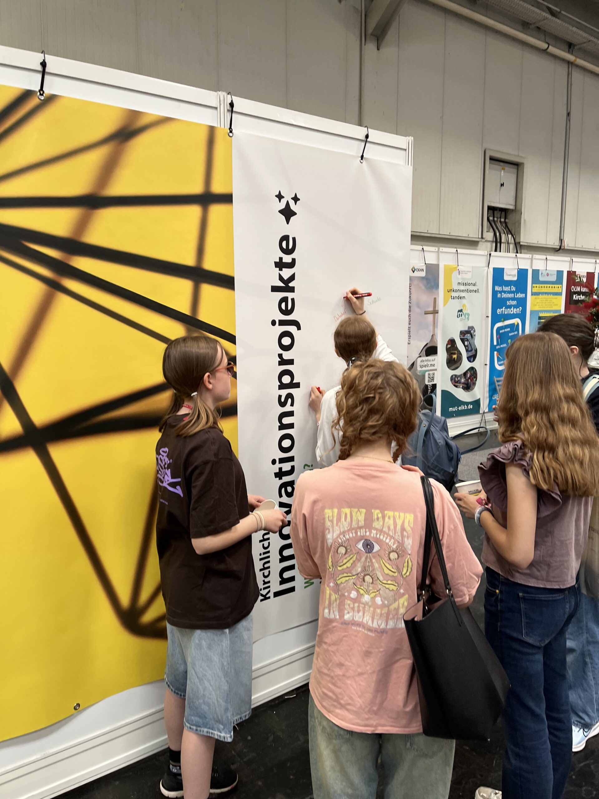 Jugendliche erkunden interaktive Ausstellung mit Interesse.